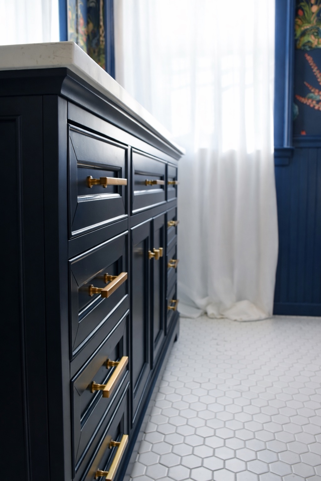 Custom navy lacquered vanity with hand-polished brass hardware and honed stone top